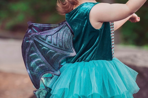 Bambino in un costume da drago in giardino