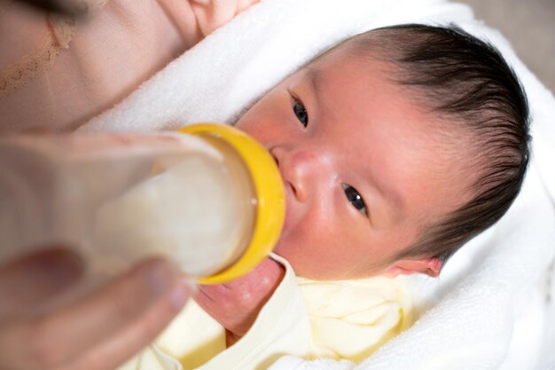 Baby drinking milk in a baby bottle