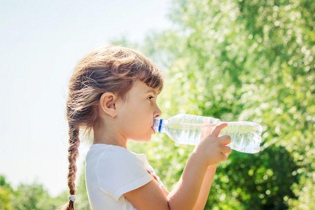 Baby drinks water from bottle. selective focus.