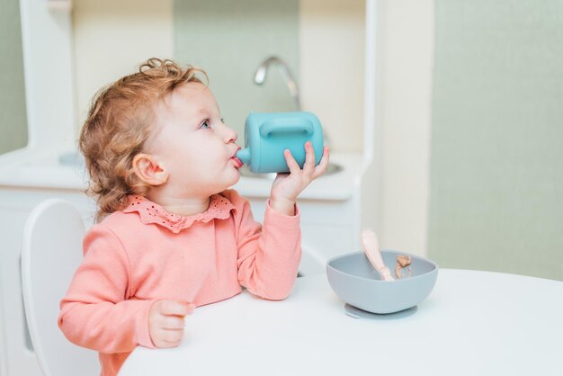 Baby drinkwater uit een plastic beker