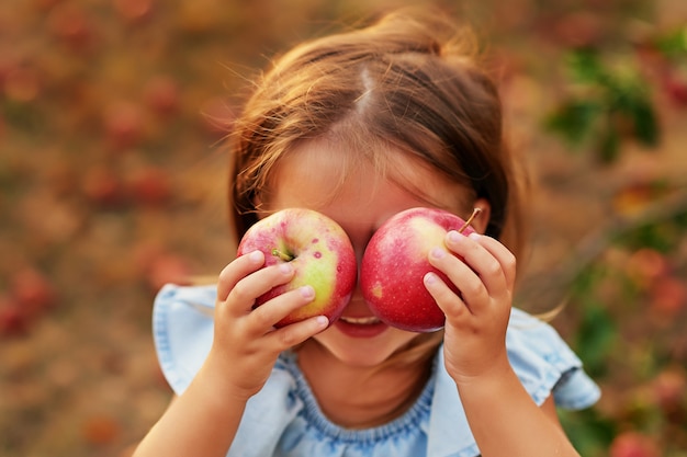 写真 秋の収穫で果物を食べる赤ちゃん。