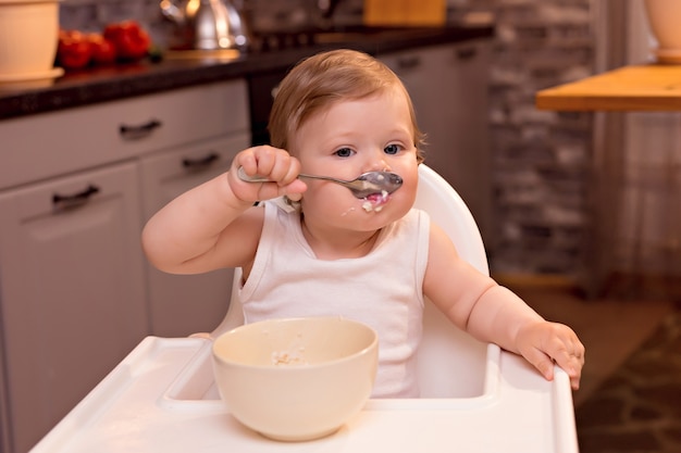 Foto bambino che mangia porridge di latte con un cucchiaio