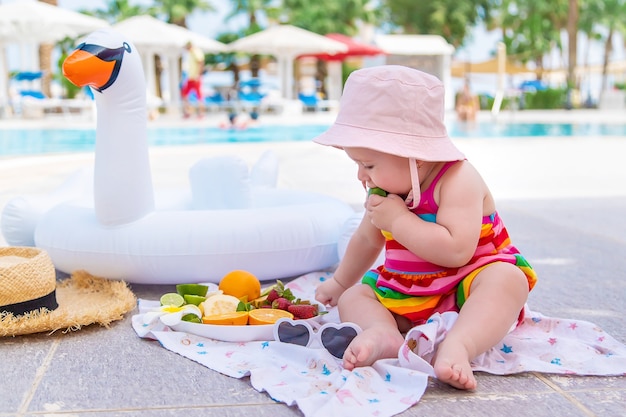Baby eats fruit on vacation. Food.