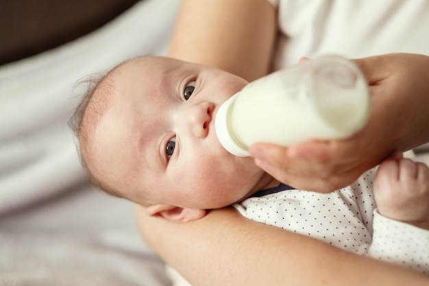 Baby eats milk from a bottle