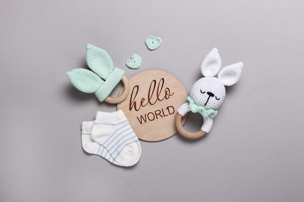 Foto baby eco houten speelgoed zitzak en bijtringenbabysokken houten tablet hello world op grijze achtergrond