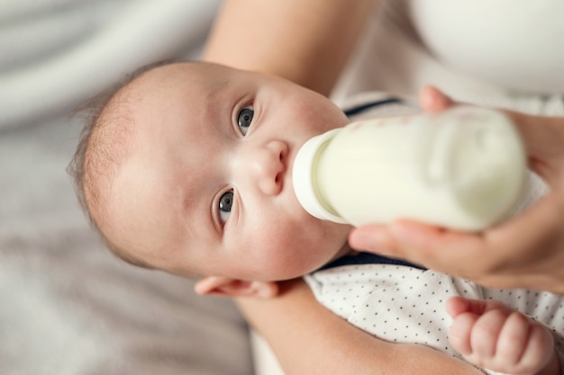 Baby eet melk uit een fles, close-up