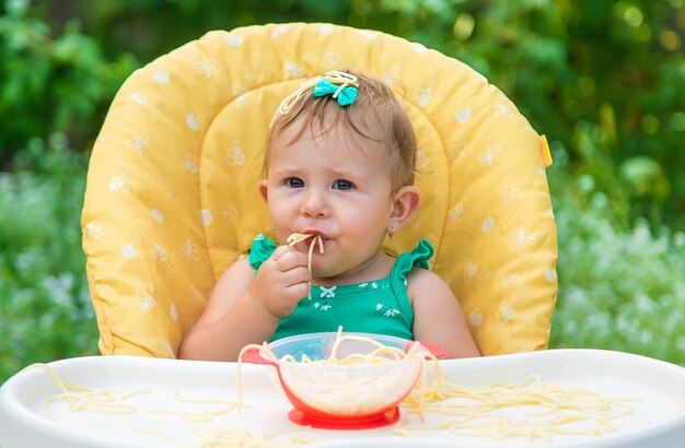 Baby eet spaghetti met zijn handen. selectieve aandacht. kind.