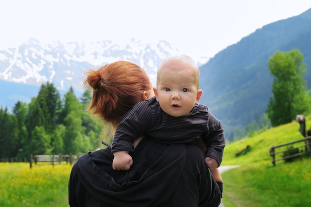Baby en moeder met de bergen van de alpen in de natuur op de achtergrond