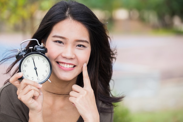 赤ちゃんの顔の時間、若い肌を持つ時代を超越したかわいいアジアの女性の女の子は時計の時間に見えます