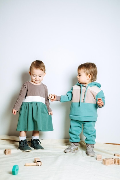 Baby fashion unisex gender neutral clothes for babies two cute\
baby girls in neutral color palette