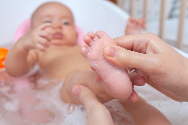 Baby feet in the bathroom, mom bathes daughter