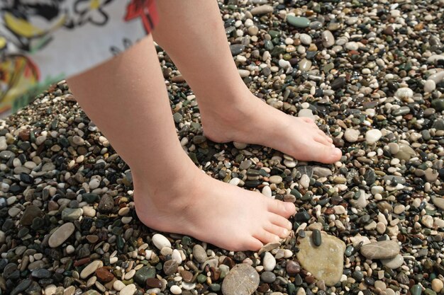 Premium Photo | Baby feet feet at the water's edge on a pebble beach