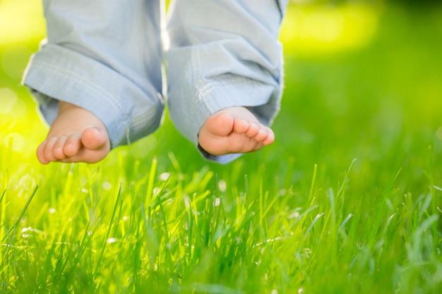 Baby feet over green spring grass