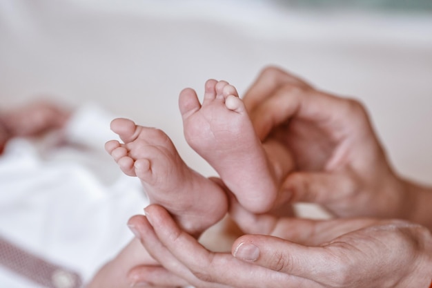 写真 母の手で赤ちゃんの足女性の小さな新生児の足形の手のクローズアップママと彼女の子供幸せな家族のコンセプトマタニティの美しい概念的なイメージ