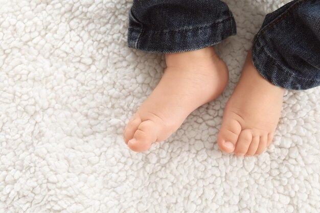Photo baby feet on light plaid closeup