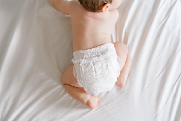 Piedi del bambino piccolo bambino in un pannolino bianco accogliente mattina prima di andare a dormire a casa