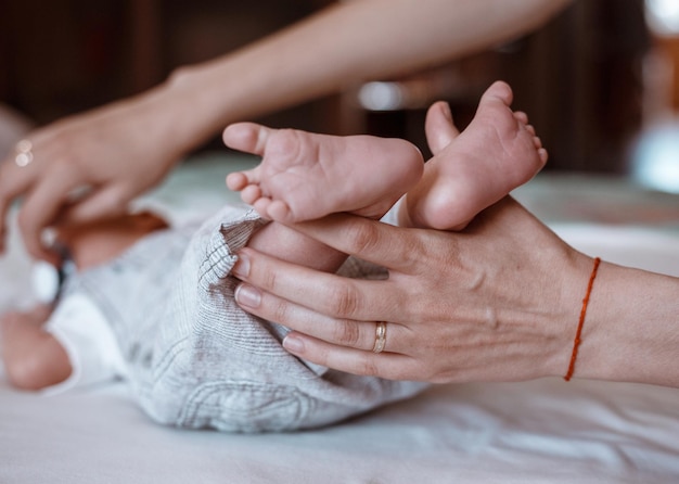 Baby feet in mother hands Tiny Newborn Baby's feet on female Shaped hands closeup Mom and her Child Happy Family concept Beautiful conceptual image of Maternity