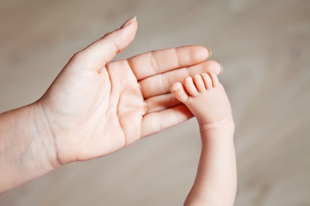 Photo baby feet in mother hands. tiny newborn baby's feet on female shaped hands closeup. mom and her child. happy family concept. beautiful conceptual image of maternity