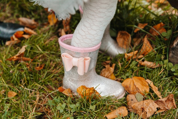 Baby feet in rubber boots close up. the child runs through the puddles on an autumn day.