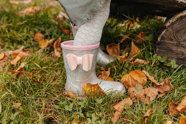 Baby feet in rubber boots close up. the child runs through the\
puddles on an autumn day.