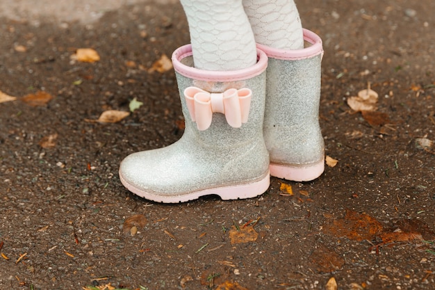 Baby feet in rubber boots close up. the child runs through the puddles on an autumn day.