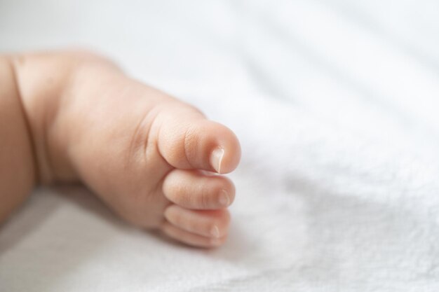 Foto piedi di bambino in un letto bianco