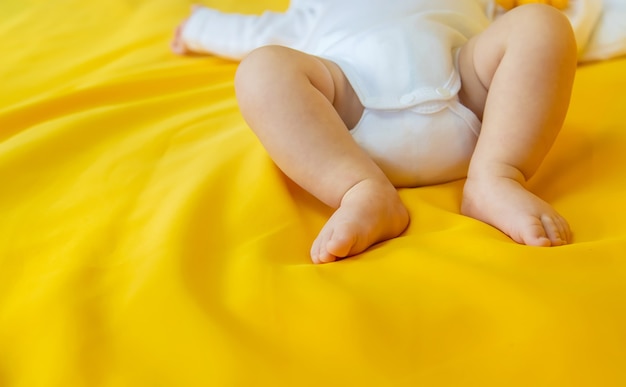 黄色の背景に赤ちゃんの足。