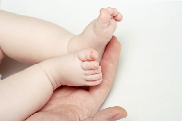 Baby feets lying on a father`s hand