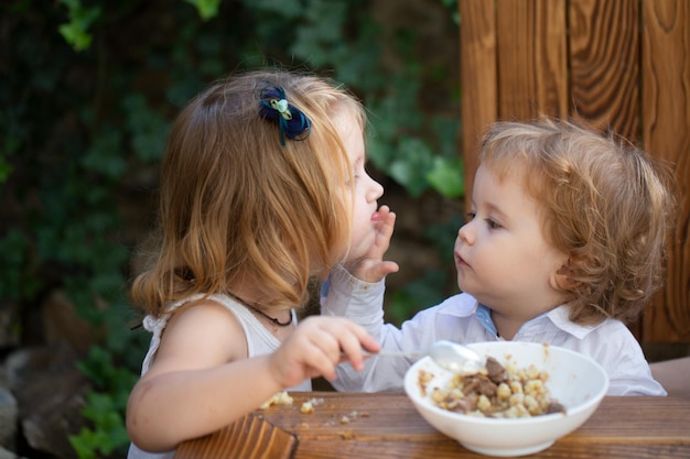 Photo baby food babies eating little girl sister feeding baby