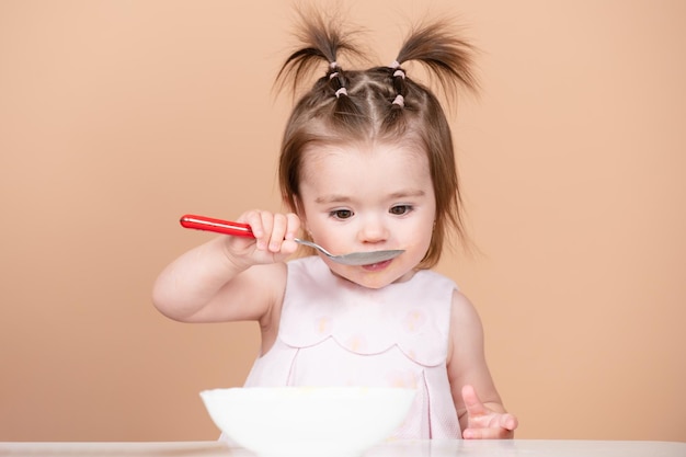 Baby food babies eating portrait of cute caucasian child kid with spoon hungry messy baby with plate...