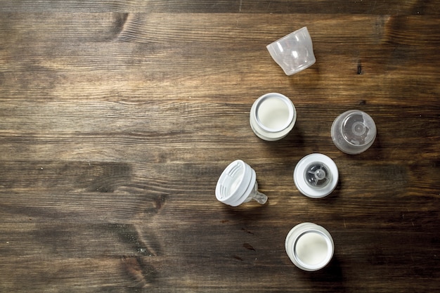 離乳食木製テーブルの上の小さなボトルのベビーミルク