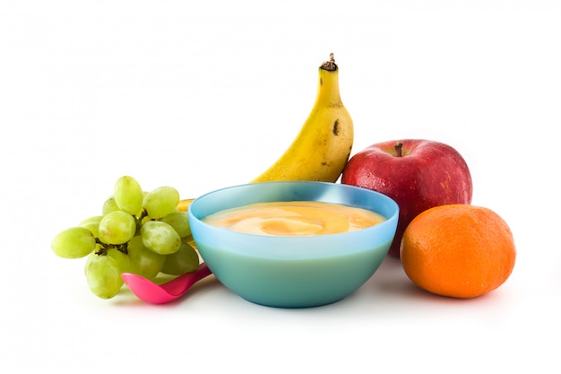 Baby food blue bowl with fruit puree isolated on white