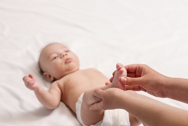 Baby foot massage, close-up of hands and foot of baby