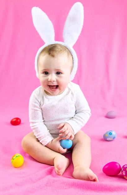 Baby gekleed als een konijn met paaseieren voor paasvakantie