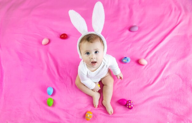 Baby gekleed als een konijn met paaseieren voor paasvakantie