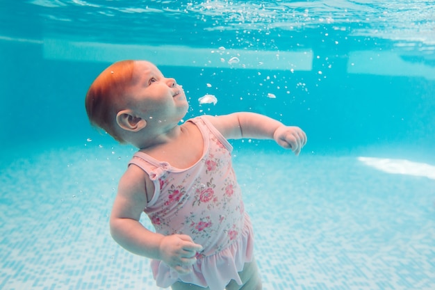 Baby. Gelukkig kind leren zwemmen, duiken onder water met plezier in het zwembad om fit te blijven. Duiken.