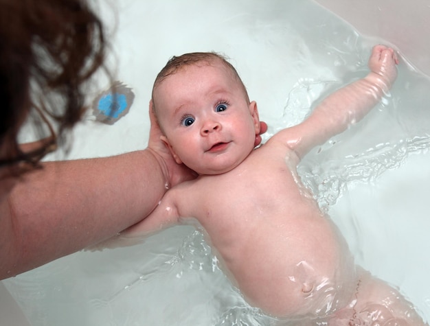 Baby girl bath by mother