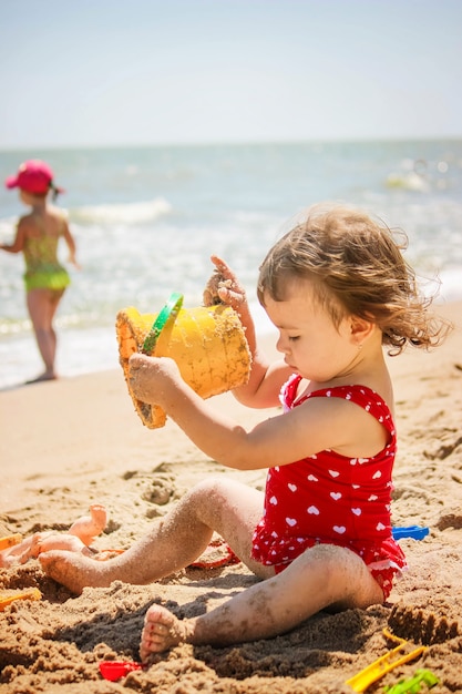 Baby girl on the beach, by the sea. Selective focus.