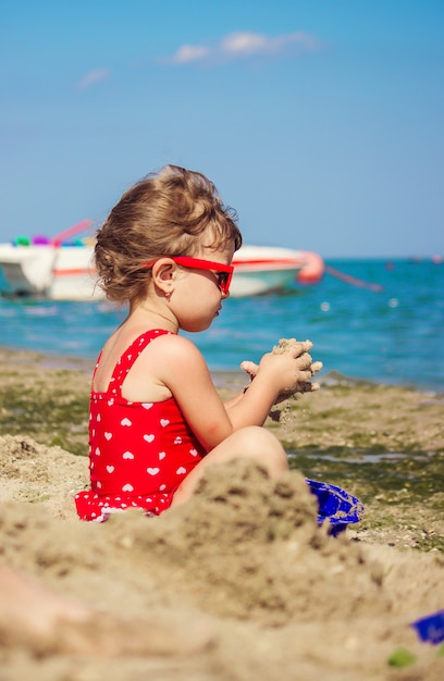 Baby girl on the beach, by the sea. Selective focus.