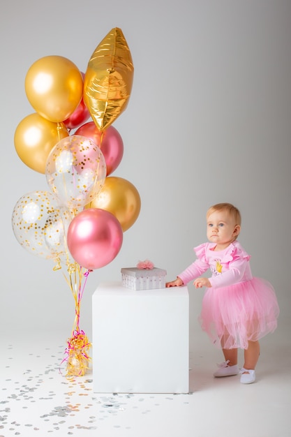 Baby girl celebrates birthday on white 