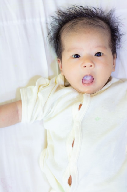 Baby girl in clean cloth lay down on bed after finish shower