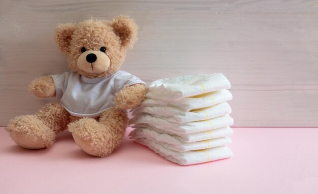 Baby girl diapers teddy sitting on pink color floor