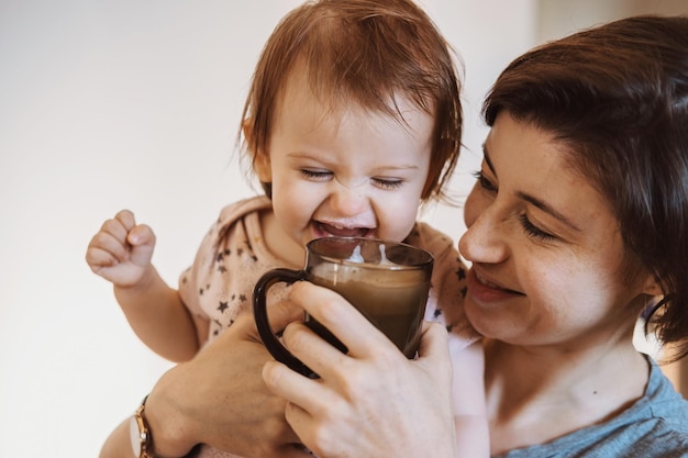 Baby girl is holding by mother arms while is drinking milk family lifestyle concept health care concept