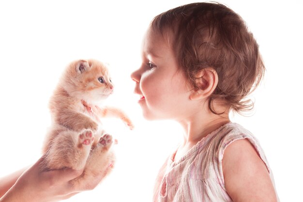 Baby girl and kitten isolated on white background