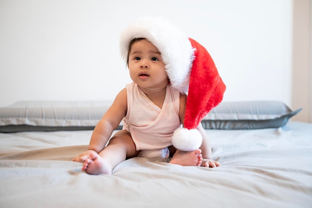 Baby girl laughing wearing santa claus hat at home