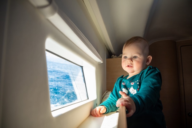 Bambina guardando la finestra dello yacht durante la navigazione da diporto in mare, croatia