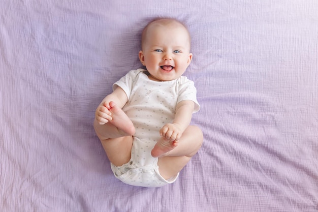 baby girl lying on bed at home