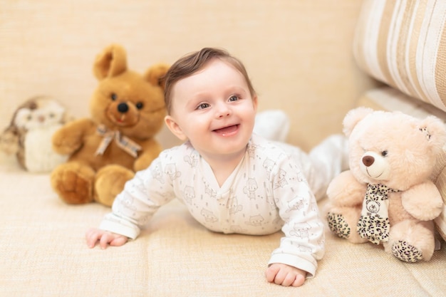 Baby girl lying on the couch among the toys at home