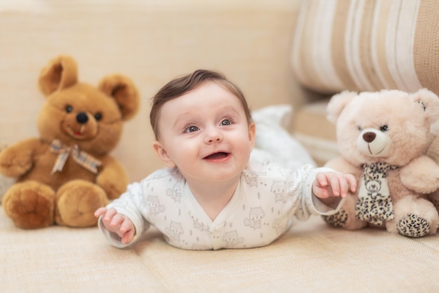 Baby girl lying on the couch among the toys at home