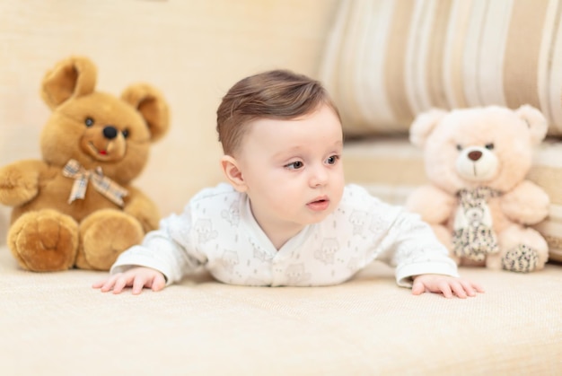 Baby girl lying on the couch among the toys at home